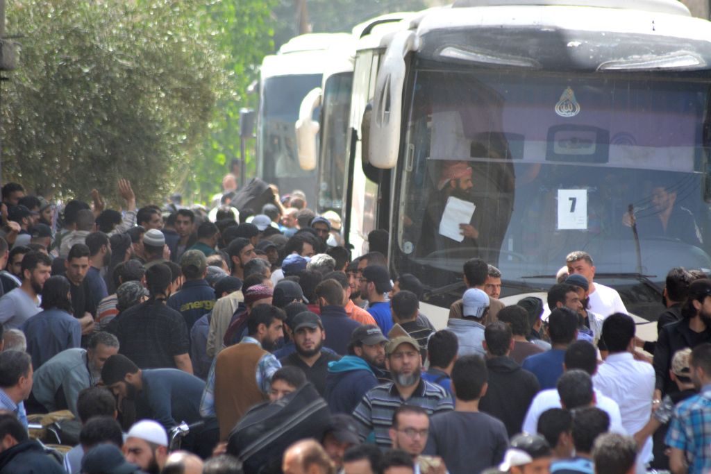 Members of the Free Syrian Army (FSA) and civilians get on the busses to be evacuated from the FSA controlled area of Yarmouk Camp in southern Damascus under the Yarmouk camp evacuation agreement, as part of the compulsory evacuation as agreed on April 29, in Damascus, Syria on May 03, 2018. A deal has been struck between the Syrian regime and the Tahrir al-Sham group to evacuate areas controlled by the latter in the Yarmouk Palestinian refugee camp near Damascus. (Photo by Rami Alsayed/Anadolu Agency/Getty Images)