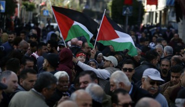 Palestinians wave national flags as they march in the streets of the occupied West Bank city of Ramallah, calling for the cessation of divisions between Fatah and Hamas and the unification of the West Bank and Gaza Strip, on January 12, 2019. 