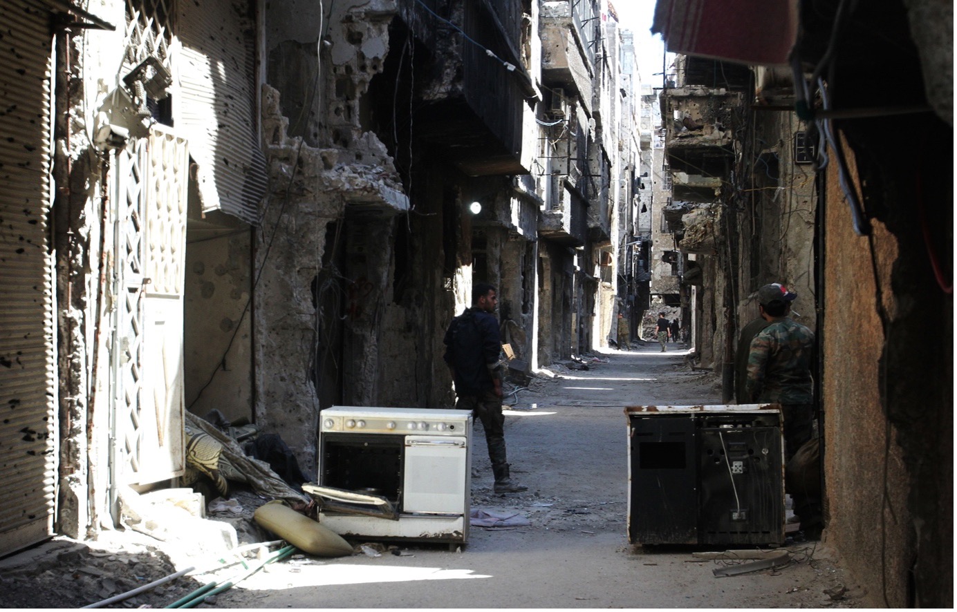 Image 3: Men stand in an alleyway of demolished buildings in Yarmouk refugee camp, Damascus, Apri 6, 2015. Photo by Youssef Karwashan/AFP via Getty Images