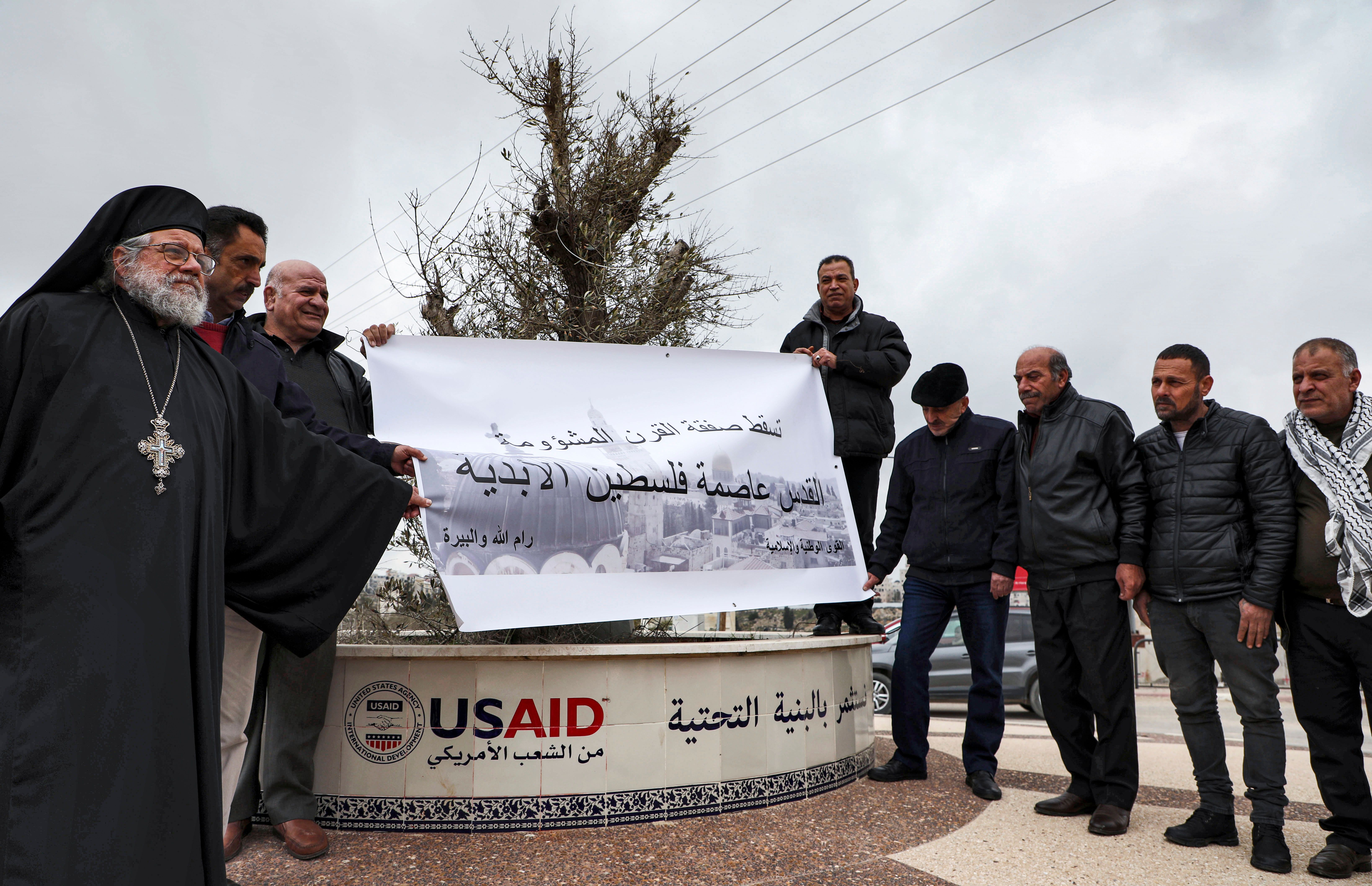 Archimandrite Abdullah Yulio (L), parish priest of the Melkite Greek Catholic church in Ramallah, stands with Palestinian protesters during a demonstration against U.S. President Donald Trump’s Middle East peace plan, in Ramallah on Feb. 4, 2020.