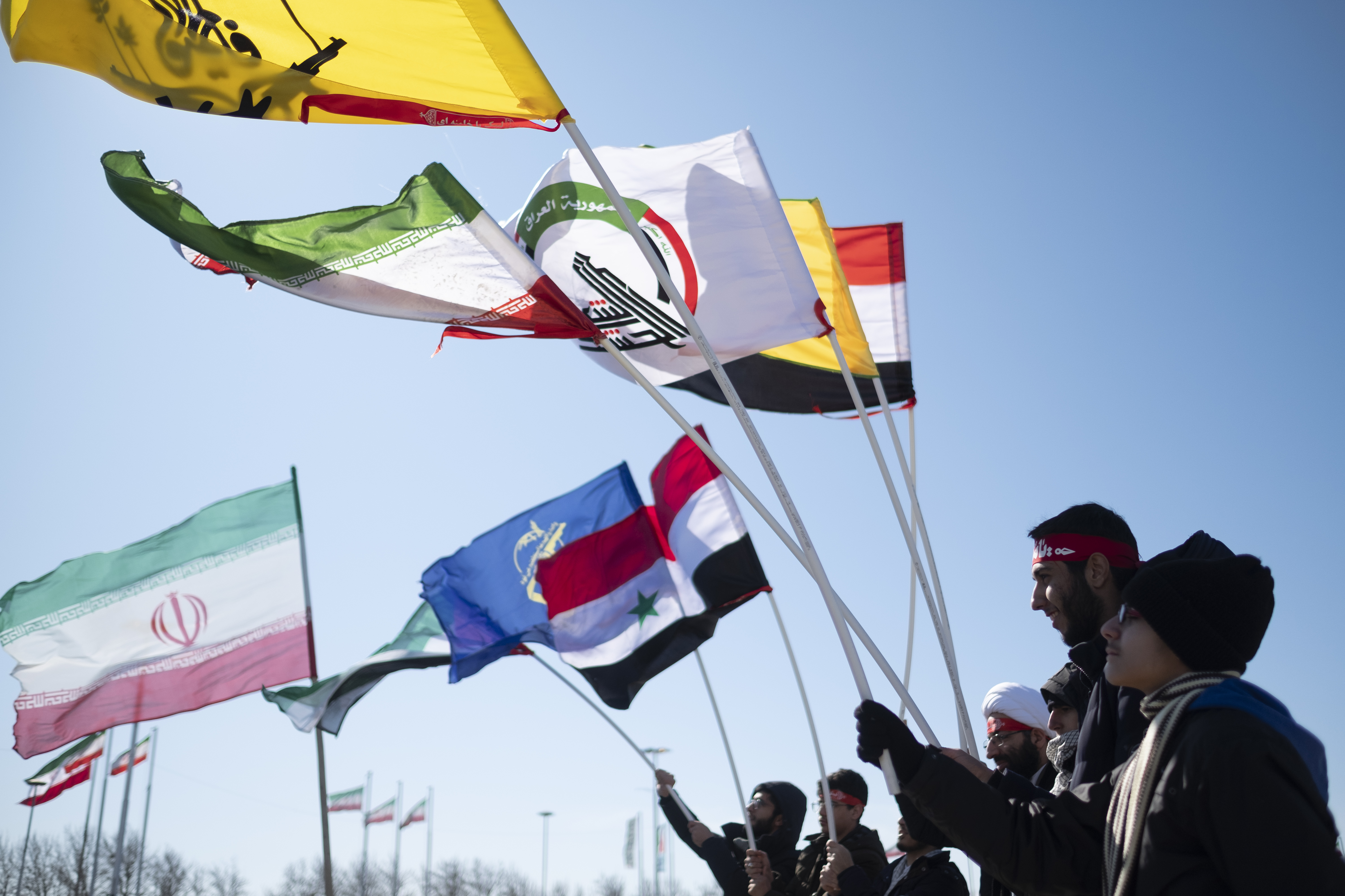 Iranians wave flags of Iran, Iraq, Iraqi Popular Mobilization Units, Hashd Shaabi, and the IRGC at a rally commemorating the Islamic Revolution in Azadi (Freedom) Square in Tehran on Feb. 11, 2020. Source: Morteza Nikoubazl/NurPhoto via Getty Images).