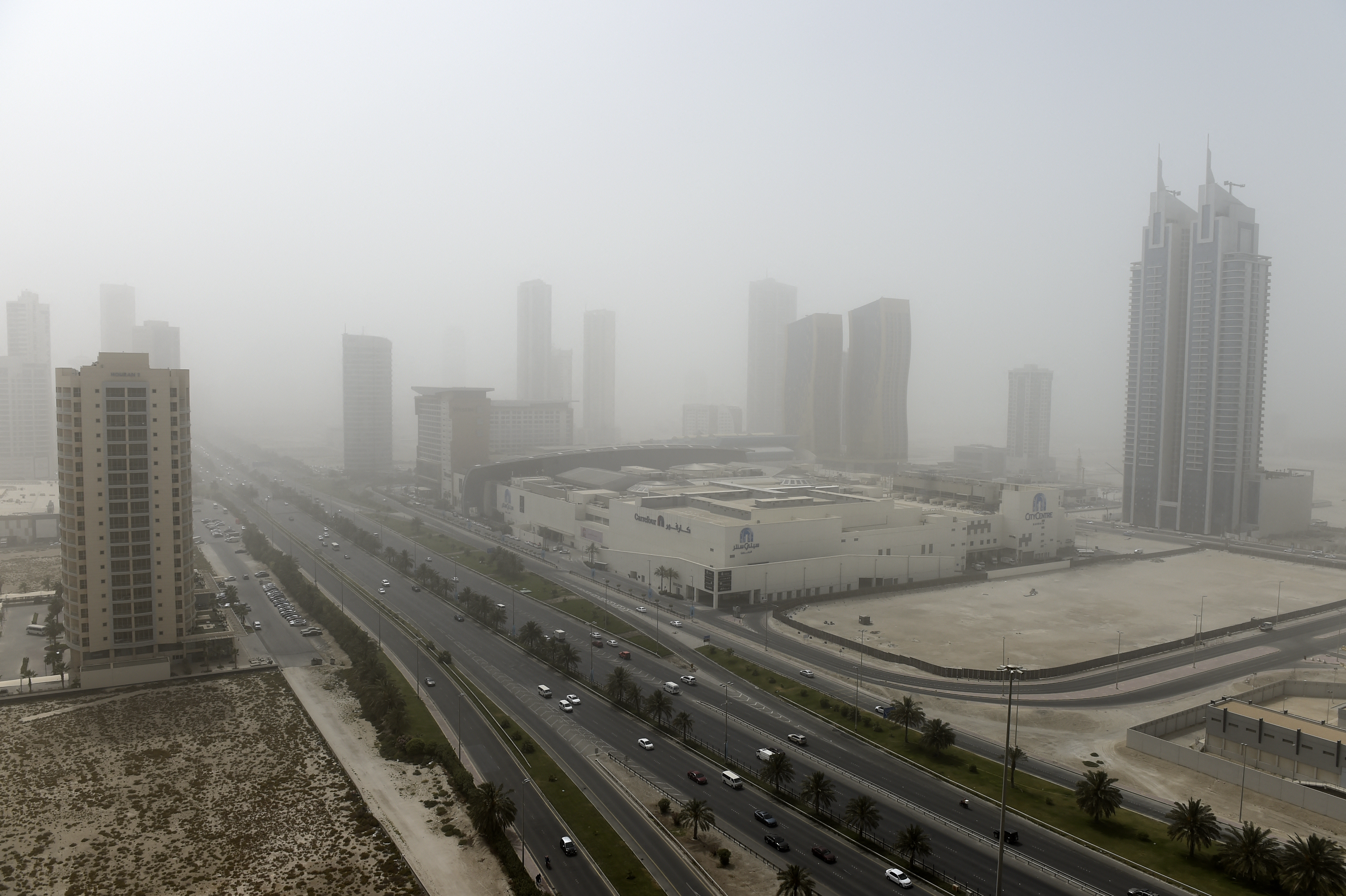 Cars drive on a highway in the Seef district during a dust storm in Manama, on May 17, 2022. Photo by MAZEN MAHDI/AFP via Getty Images.