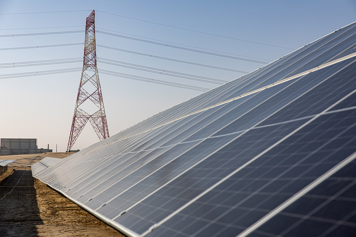 Photo above: An electricity transmission tower beyond photovoltaic panels at the al-Dhafra solar project, constructed by Électricité de France SA and Jinko Power Technology Co. Ltd., in Abu Dhabi on Jan. 31, 2023. Photo by Christopher Pike/Bloomberg via Getty Images.