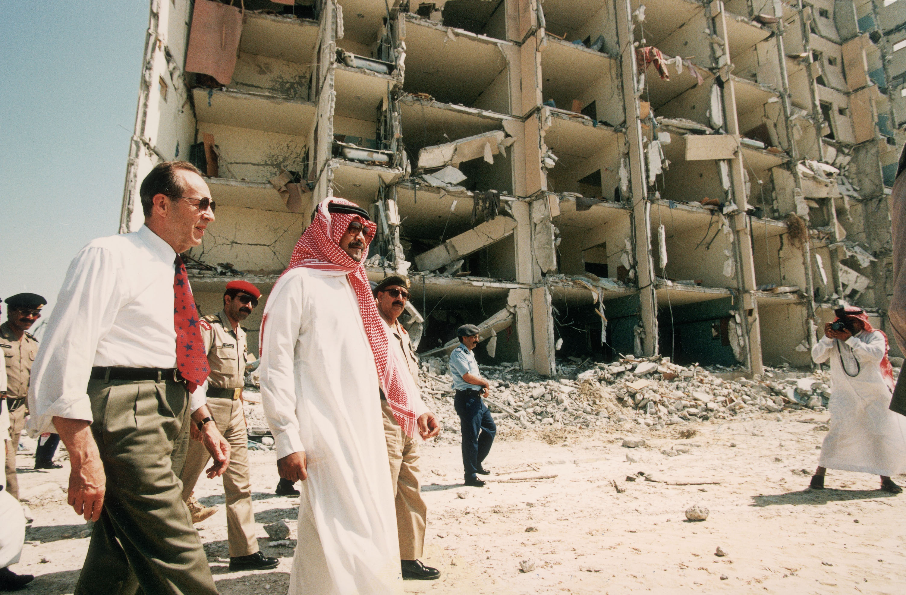 Photo above: Then-U.S. Secretary of Defense William Perry tours the wreckage of Khobar Towers in Dhahran, Saudi Arabia on June 29, 1996 after a truck bomb exploded four days previously, killing 19 American servicemen residing there. Photo by Scott Peterson/Getty Images.
