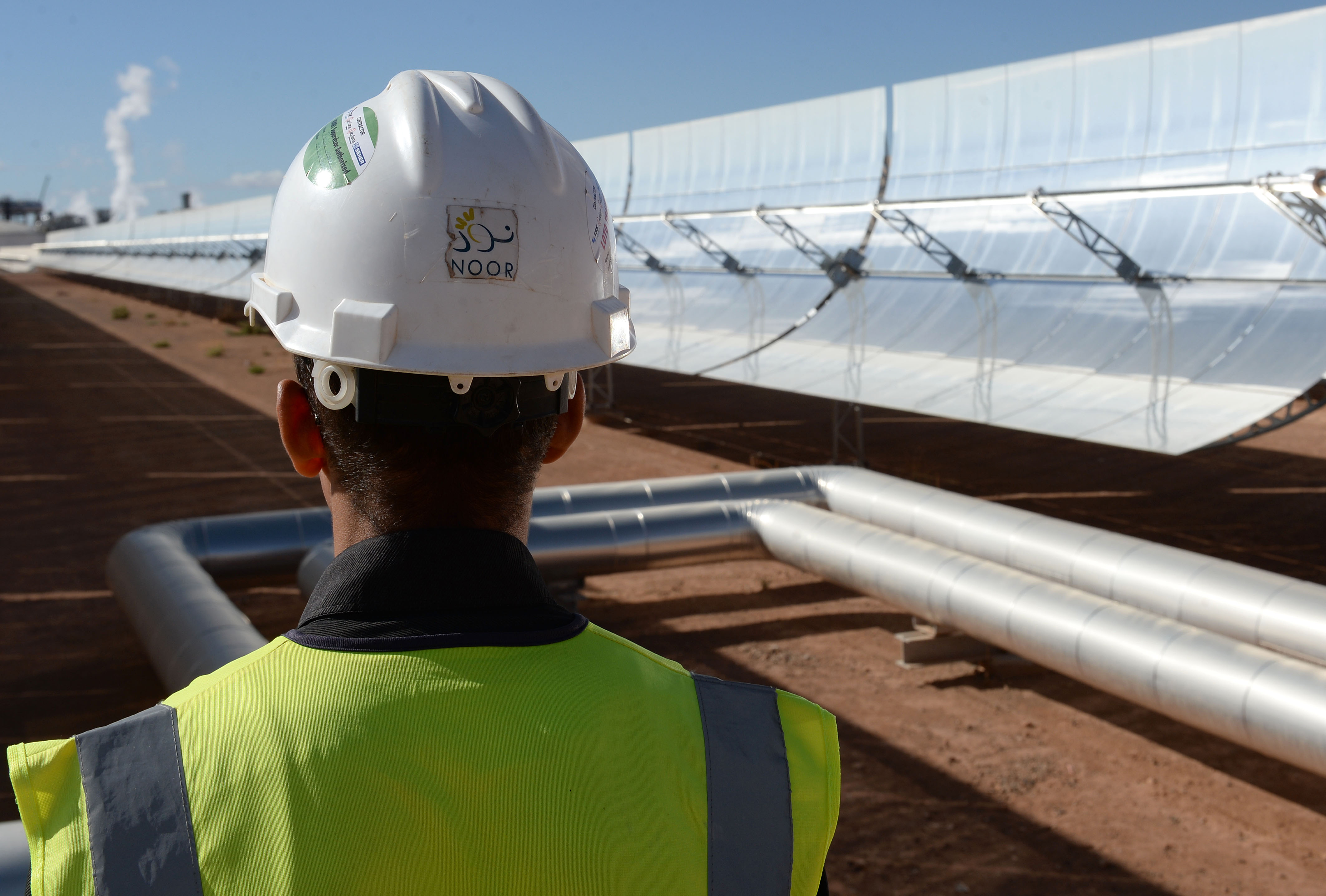 A worker standing in front of solar mirrors at the Noor 1 Concentrated Solar Power plant, some 20km outside of Ouarzazate, Morocco, on Oct. 17, 2015. Photo by Fadel Senna/AFP via Getty Images.