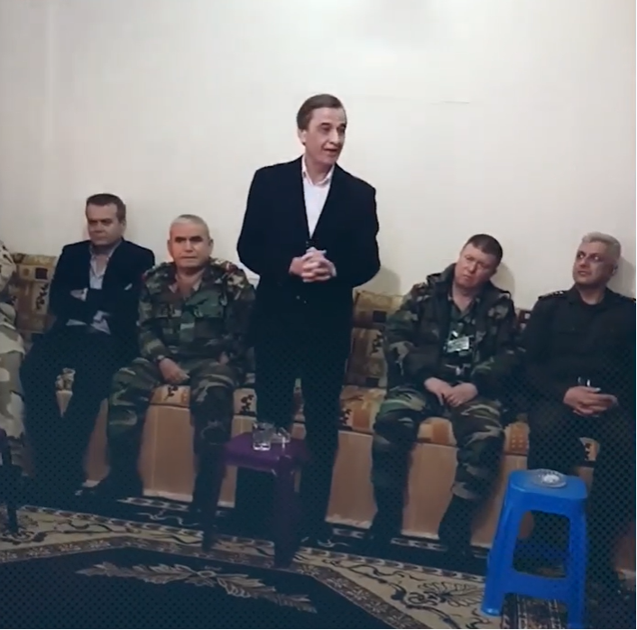 Luka (standing) meeting with local notables in Tafa, Daraa, in February 2021 alongside Russian and regime officers.