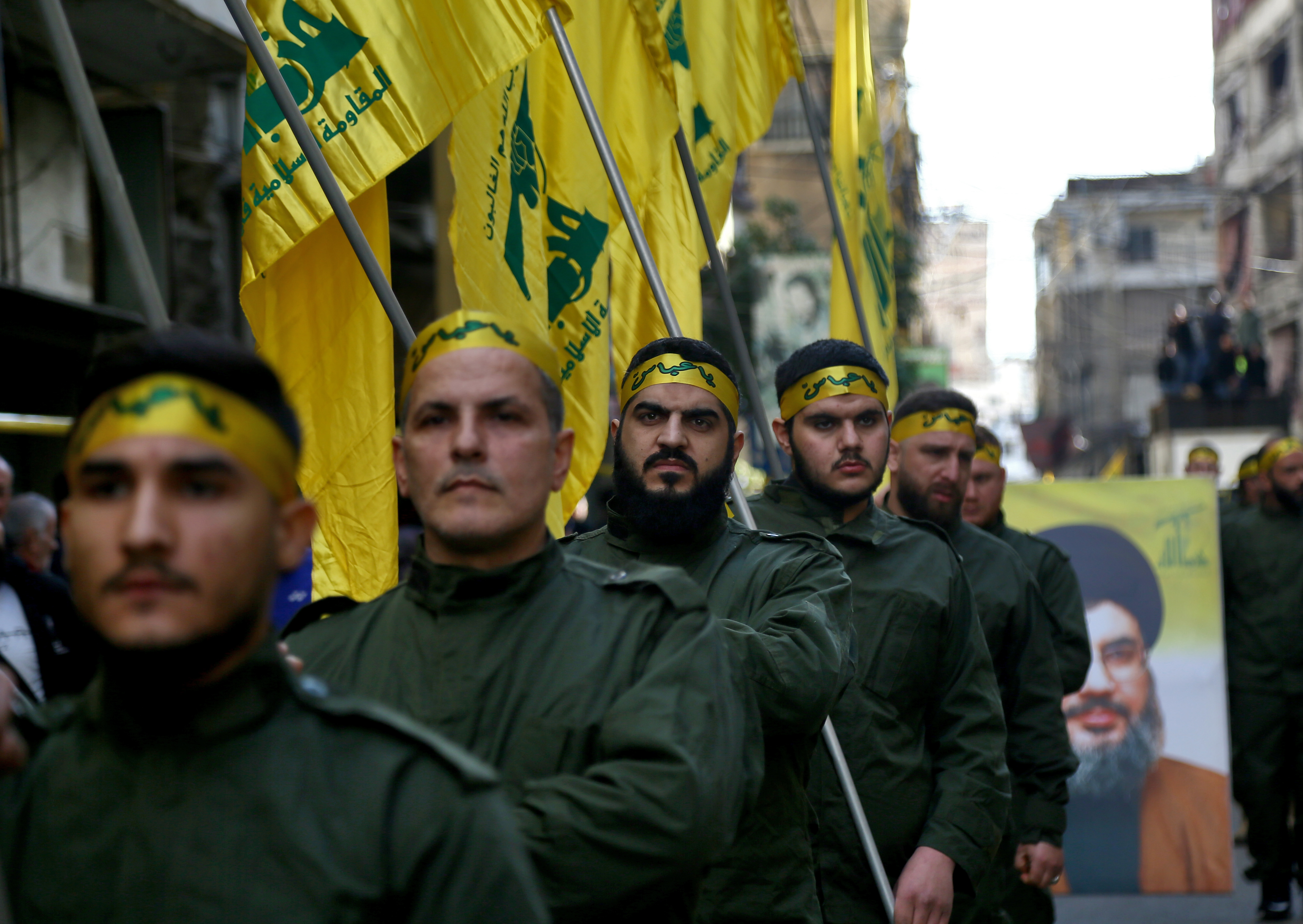 Pro-Iran Hezbollah militants hold flags during a funeral procession for five of their colleagues killed in clashes with the Turkish army in the Syrian province of Idlib, March 1, 2020. Photo by Marwan Naamani/picture alliance via Getty Images.