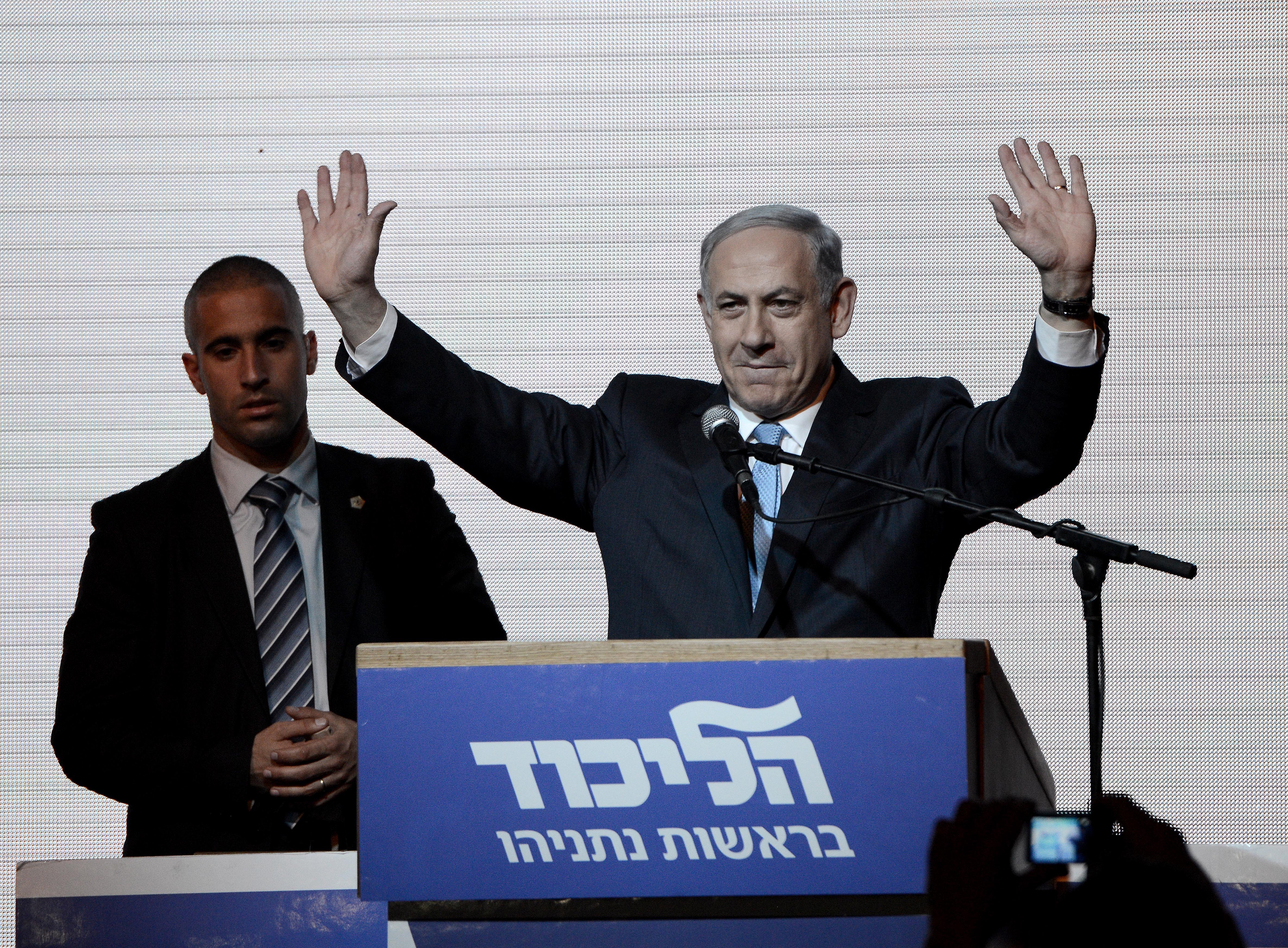 Israeli Prime Minister and the leader of the Likud Party Benjamin Netanyahu greets supporters at the party's election headquarters after the first results of the Israeli general election on March 18, 2015