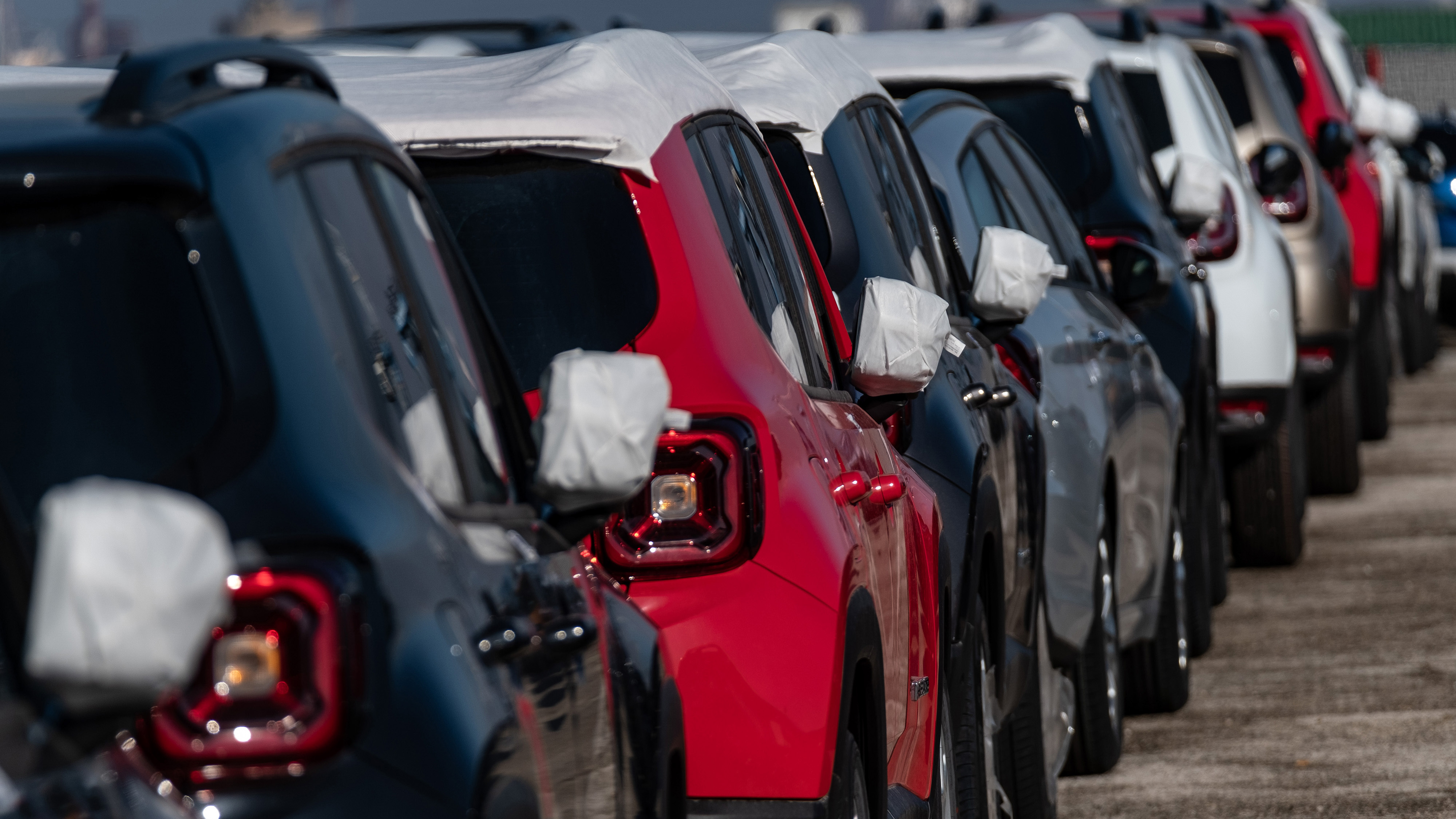 Protective covers sit on the wing mirrors of a line of new Dacia Sandero automobiles after being shipped from Morocco, at the Port of Marseille, on November 17, 2019. Photo by Balint Porneczi/Bloomberg via Getty Images.