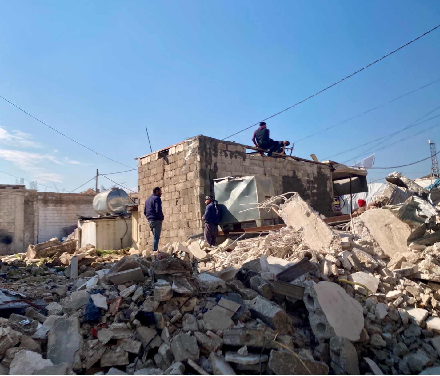 Only a week after the quake, communities had already come together to repair the cracked walls and foundations of their homes. In Atareb, locals re-cement a small building that remained standing amid a sea of destruction. 