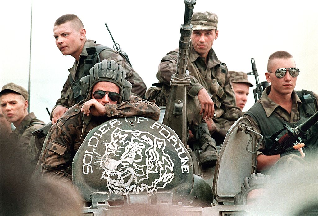 Members of the Russian Army sit atop an armored personal vehicle with a logo of "Soldier of Fortune" 18 July 1995 in Grozny.