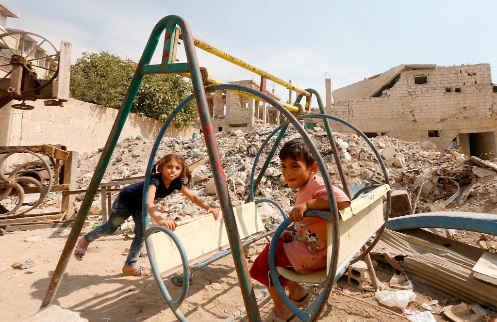 Syrian children play amidst badly damaged buildings in Zabdin, in the eastern Ghouta region on the outskirts of Damascus, on October 08, 2018. 