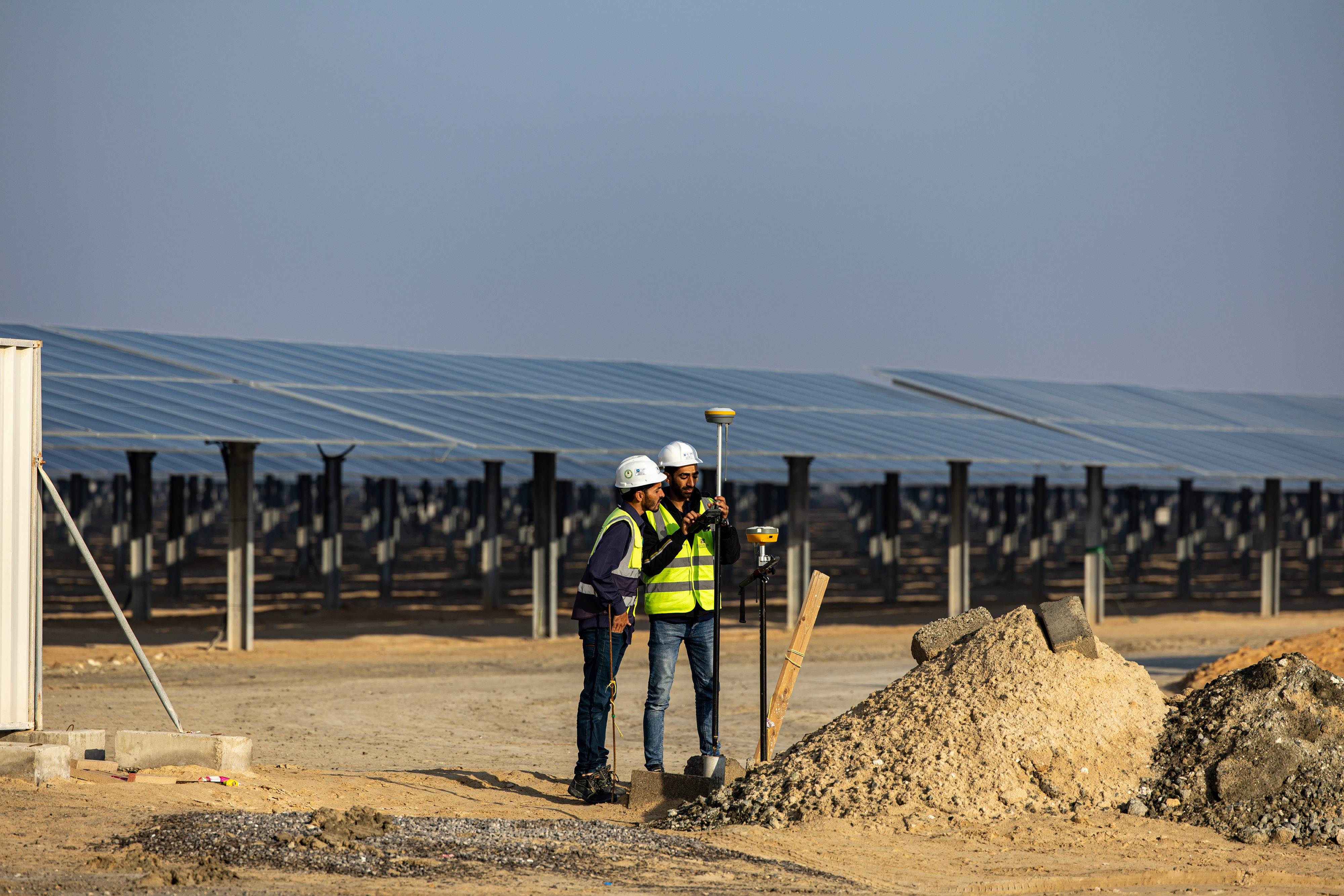 Workers install equipment at al-Dhafra solar project, constructed by Electricite de France and Jinko Power Technology, in Abu Dhabi, on January 31, 2023. Photo by Christopher Pike/Bloomberg/via Getty Images.