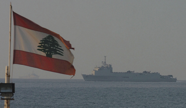 Lebanese flag waving over blue sea with ship
