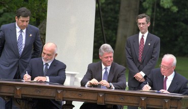 The Israel-Jordan peace treaty being signed in 1994. US President Bill Clinton watches Jordan's King Hussein and Israeli Prime Minister Yitzhak Rabin sign the treaty on the White house lawn