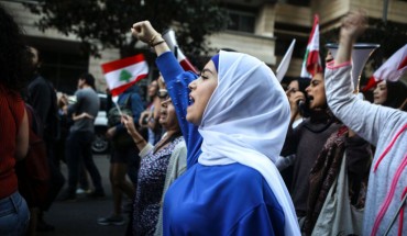 Lebanese anti-government protesters shout slogans as they march on the former demarcation line separating Beirut on December 1, 2019. 