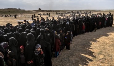 Civilians evacuated from the Islamic State (IS) group's embattled holdout of Baghouz wait for bread and water at a screening area held by the Kurdish-led Syrian Democratic Forces (SDF), in the eastern Syrian province of Deir Ezzor, on March 5, 2019. - More than 7,000 people, mostly women and children, have fled the shrinking pocket over the past two days, as US-backed forces press ahead with an offensive to crush holdout jihadists. (Photo by Bulent KILIC / AFP) (Photo credit should read BULENT KILIC/AFP via