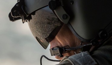 A partial view of the Iraqi capital Baghdad is reflected in the visor of a US Army helicopter crew member as he looks out of a Chinook helicopter flying from the US Embassy to Baghdad International airport, following the helicopter of US secretary of State Mike Pompeo, on January 9, 2019. 