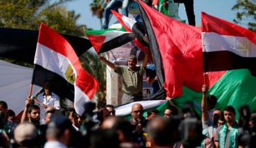 A man waves a Palestinian flag while protesting. 