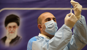 An Iranian medical personnel fills a syringe with the Russian Sputnik-V vaccine, The first registered vaccine against COVID-19, while standing next to a portrait of Irans Supreme Leader Ayatollah Ali Khamenei during a ceremony of initiation of general vaccination against the new coronavirus disease, in a hospital in western Tehran on February 9, 2021. (Photo by Morteza Nikoubazl/NurPhoto via Getty Images)