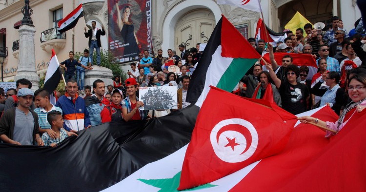 Tunisian protestors wave their national and the Syrian flags on May 6, 2013. 