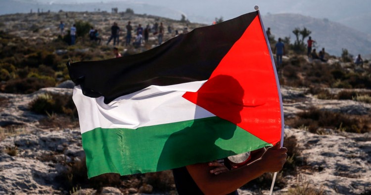 A Palestinian protester waves a Palestinian flag during a demonstration in the village of Ras Karkar west of Ramallah in the occupied West Bank on September 4, 2018. 