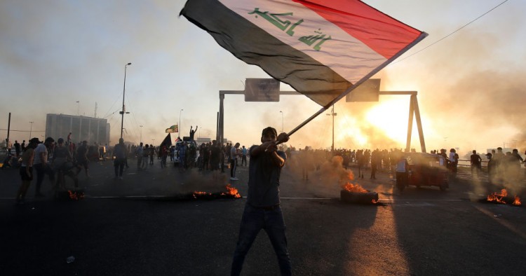 An Iraqi protester waves the national flag during a demonstration against state corruption, failing public services, and unemployment, in the Iraqi capital Baghdad on October 5, 2019.