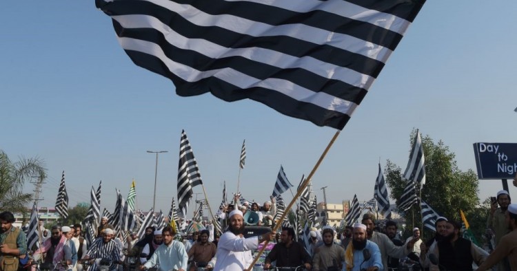 An activists of the Jamiat Ulema-e-Islam waves the party flag during the anti-government "Azadi March" towards Islamabad, in Peshawar on October 27, 2019.