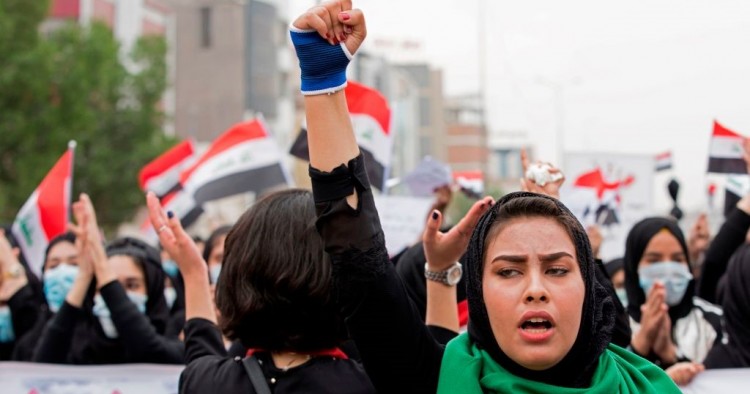 An Iraqi woman raises her fist as she takes part in an anti-government march in the center of the southern city of Basra on December 2, 2019.