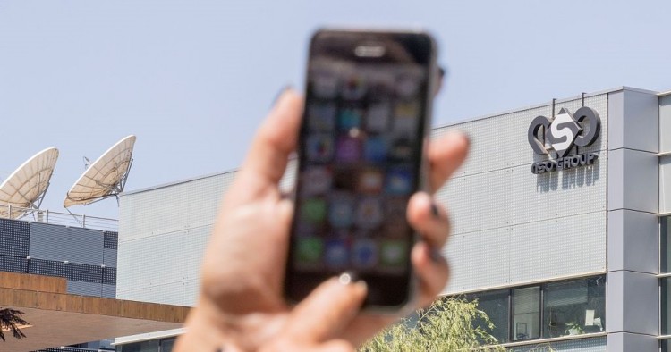An Israeli woman uses her iPhone in front of the building housing the Israeli NSO group, on August 28, 2016, in Herzliya, near Tel Aviv. 