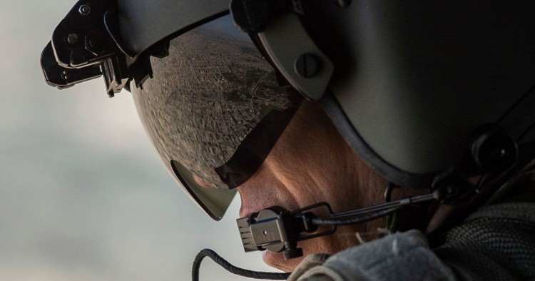 A partial view of the Iraqi capital Baghdad is reflected in the visor of a US Army helicopter crew member as he looks out of a Chinook helicopter flying from the US Embassy to Baghdad International airport, following the helicopter of US secretary of State Mike Pompeo, on January 9, 2019. 