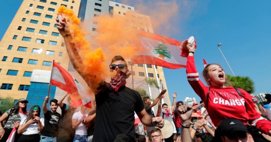 Lebanese students wave the national flag and chant slogans as they gather outside the Ministry of Education and Higher Education during ongoing anti-government protests, in the capital Beirut on November 8, 2019.