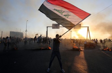 An Iraqi protester waves the national flag during a demonstration against state corruption, failing public services, and unemployment, in the Iraqi capital Baghdad on October 5, 2019.