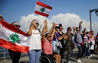 Lebanese people hold hands as they form a human chain, that stretched out along the coast from the capital Beirut to northern and southern Lebanon, symbolizing national unity, on the 11th day of anti-government protests across Lebanon. 