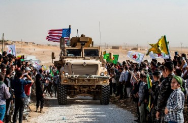  Syrian Kurds gather around a US armoured vehicle during a demonstration against Turkish threats next to a US-led international coalition base on the outskirts of Ras al-Ain town in Syria's Hasakeh province near the Turkish border on October 6, 2019. 