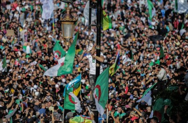 Algerians take part in an anti-government demonstration demanding the ouster of officials who served under ex-president Abdelaziz Bouteflika as they marked the 65th anniversary of the country's fight for independence from France. 