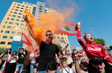 Lebanese students wave the national flag and chant slogans as they gather outside the Ministry of Education and Higher Education during ongoing anti-government protests, in the capital Beirut on November 8, 2019.