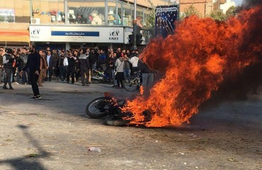 Iranian protesters gather around a burning motorcycle during a demonstration against an increase in gasoline prices in the central city of Isfahan, on November 16, 2019.