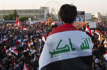 An Iraqi protester deaped in his national flag takes part in an anti-government protest in the southern city of Basra on November 1, 2019.