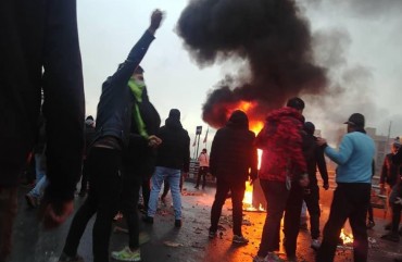Iranian protesters gather around a fire during a demonstration against an increase in gasoline prices in the capital Tehran, on November 16, 2019. 