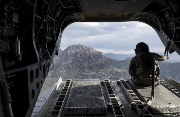 A US soldier looks at a mountain range in Afghanistan's Logar Province from a US Chinook helicopter on May 28, 2014.