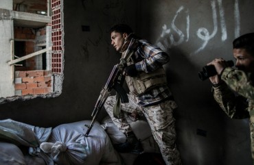 Fighters of the UN-backed Government of National Accord take cover during clashes with Libyan National Army forces at Al-Nahr frontline in Tripoli, Libya, on March 8, 2020.