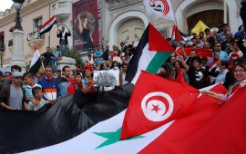 Tunisian protestors wave their national and the Syrian flags on May 6, 2013. 