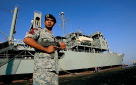 An Iranian navy special forces known as Takavaran wearing a similar uniform worn by the US military and holding an Israeli made Uzi sub-machine gun stands guard near the Iranian Kharg replenishment ship docked in the Red Sea Sudanese town of Port Sudan on October 31, 2012. 