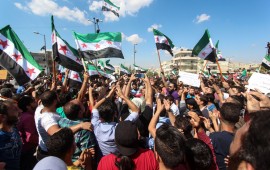  People seen waving flags during the protest against the Syrian regime in Idlib in September 2018.