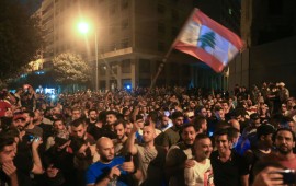Demonstrators wave a flag during a protest against a government decision to tax calls made on messaging applications on October 17, 2019 outside the government palace in Beirut. 