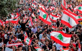 Lebanese protesters wave national flags during demonstrations to demand better living conditions and the ouster of a cast of politicians who have monopolised power and influence for decades, on October 21, 2019 in downtown Beirut. 