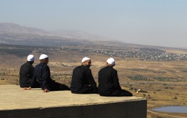 Cover photo: Druze men in the Israeli-annexed Golan Heights look out across the southwestern Syrian province of Quneitra, visible across the border on July 7, 2018. (Photo by JALAA MAREY/AFP/Getty Images)