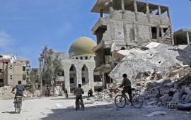 Syrian children ride their bike past destroyed buildings in the former rebel-held town of Zamalka, in Eastern Ghouta on April 5, 2018. / AFP PHOTO / STRINGER (Photo credit should read STRINGER/AFP via Getty Images)