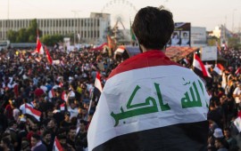 An Iraqi protester deaped in his national flag takes part in an anti-government protest in the southern city of Basra on November 1, 2019.